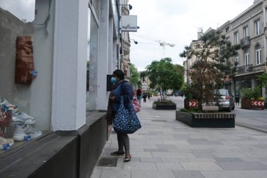 Yüz maskesi takan insanlar, 12 Mayıs 2020 Pazartesi günü Brüksel 'de koronavirüsün, COVID-19' un yayılmasını önlemek için, tecrit sürecinin kademeli kaldırılması sırasında ticari caddede yürürler..