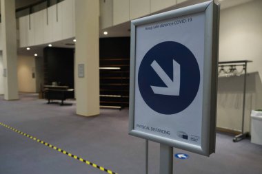 Belçika 'nın Brüksel kentindeki Avrupa Parlamentosu bünyesinde 13 Mayıs 2020 tarihli genel kurul toplantısında COVID-19 salgını için güvenlik tedbirlerine ilişkin bir işaret yer alıyor..