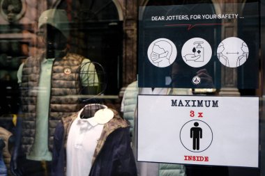 8 Mayıs 2020 'de Brüksel, Belçika' daki covid-19 salgını sırasında müşterilere perakende mağazasının girişinde alışveriş yaparken toplumsal mesafeli olmayı tavsiye eden bir poster.