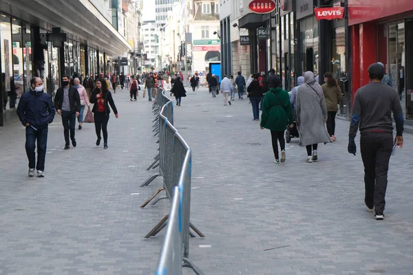 Yüz maskesi takan insanlar, 12 Mayıs 2020 Pazartesi günü Brüksel 'de koronavirüsün, COVID-19' un yayılmasını önlemek için, tecrit sürecinin kademeli kaldırılması sırasında ticari caddede yürürler..