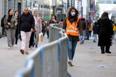 Bir kahya 11 Mayıs 2020 'de Belçika' nın Brüksel kentindeki ana ticaret caddesinde kalabalığa yardım ediyor..