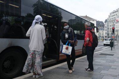 4 Mayıs 2020 'de Brüksel, Belçika' da bir kamu otobüsünden koruyucu maskeler takan banliyö halkı çıktı.