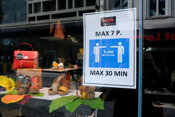 在2020年5月8日比利时布鲁塞尔发生Covid 19疫情期间 一张海报建议顾客在零售店门口购物时要注意社交场合的距离 — 图库照片