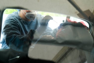 Bir sağlık çalışanı 5 Mayıs 2020 'de Belçika' daki Liege Üniversitesi Hastanesi 'nde arabalı servis alanında koronavirüs testi uygular..