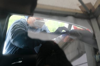 Bir sağlık çalışanı 5 Mayıs 2020 'de Belçika' daki Liege Üniversitesi Hastanesi 'nde arabalı servis alanında koronavirüs testi uygular..