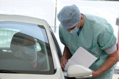 Bir sağlık çalışanı 5 Mayıs 2020 'de Belçika' daki Liege Üniversitesi Hastanesi 'nde arabalı servis alanında koronavirüs testi uygular..