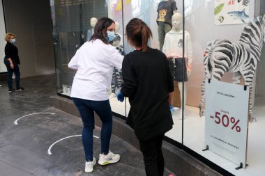 Bir giyim mağazasının çalışanları son ayarlamaları 11 Mayıs 2020 'de Brüksel' de, Covid-19 hastalığının yayılması ile mücadele etmek için iki ay önce başlatılan tecridin ilk gününde yapıyorlar.