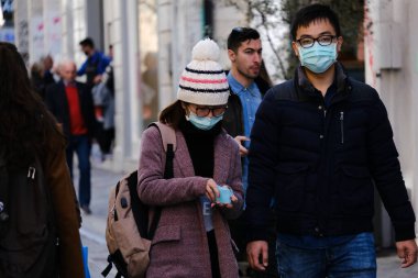 Koronavirüs salgını sonrasında koruyucu maskeler takan insanlar, 28 Şubat 2020 'de Yunanistan' ın Atina kentindeki bir alışveriş bölgesinde dolaşmaya başladılar..