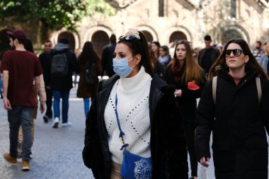 Koronavirüs salgını sonrasında koruyucu maskeler takan insanlar, 28 Şubat 2020 'de Yunanistan' ın Atina kentindeki bir alışveriş bölgesinde dolaşmaya başladılar..