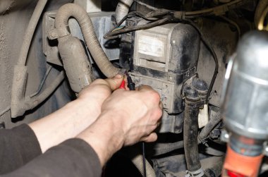 Bir otomobil uzmanı otomatik tanılama için bir ölçüm cihazı kullanır