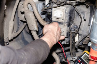 Bir otomobil uzmanı otomatik tanılama için bir ölçüm cihazı kullanır