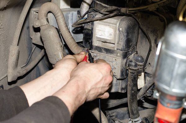 Автомобильный эксперт использует измерительный прибор для автоматической диагностики
