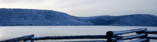 Vecchio molo sul fiume nella stagione invernale. Il fiume non si è ghiacciato. Tramonto soleggiato sul fiume. Sullo sfondo è una foresta invernale . — Foto Stock