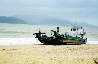 Bir fırtınadan sonra, Vietnam sahilinde karaya vurmuş bir balıkçı gemisi..