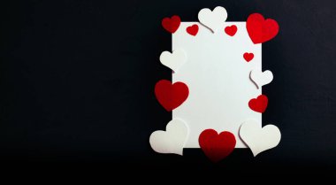 Farklı boylarda ve renklerde 13 dekoratif kalp. Yatay konum. Sağ tarafta, beyaz bir kağıt parçası kalplerle süslenir. Sevgililer Günü konsepti.