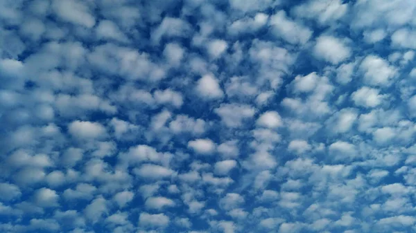 Beaucoup de nuages blancs sur fond de ciel bleu . — Photo