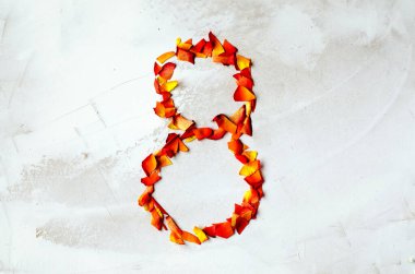 8 numara. Yapraktan serilmiş sekiz kırmızı-sarı gül. Yakın plan. Boşluğu kopyala