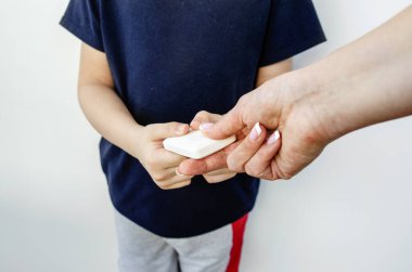 Sabunla düzenli el yıkama, bakteri dezenfeksiyonu. Koronovirüsün yayılması bağlamında hijyenik bir kavram. Bir kadın eli, beyaz bir dezenfektan sabunu eline geçirir.