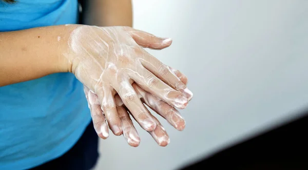 Regular hand washing with soap, disinfection of bacteria. Hygienic concept in the context of the spread of coronovirus. Hands of a teenage girl wash their hands with disinfectant soap. Hands in dense