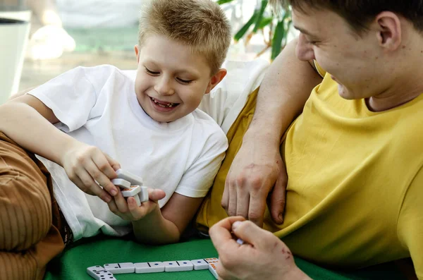 Ein Junger Vater Spielt Brettspiele Dominosteine Mit Seinem Sohn Auf lizenzfreie Stockfotos