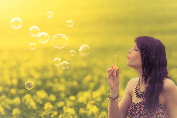 Mooie vrouw grappig zeepbellen blazen in de zomer natuur — Stockfoto