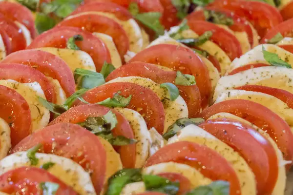 Tomates saludables y mozzarella picados en fila de entrantes de ensalada — Foto de Stock