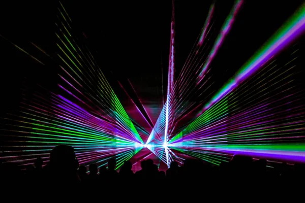 Colorful laser show nightlife club stage with party people crowd