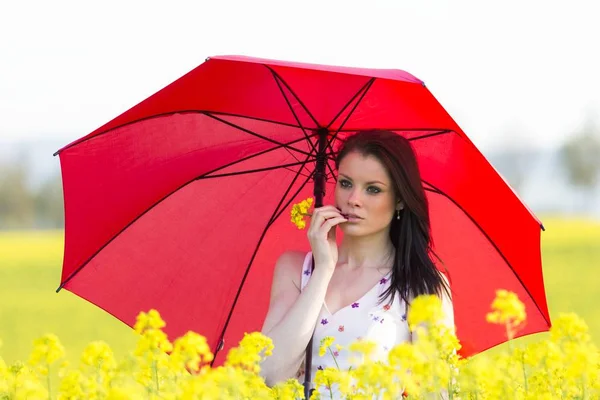 Schöne junge Frau mit Sonnencreme oder Regenschirm — Stockfoto