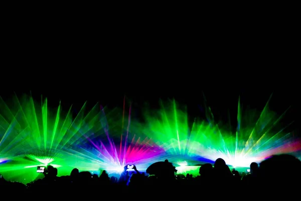 Colorful laser show nightlife club stage with smartphone filming