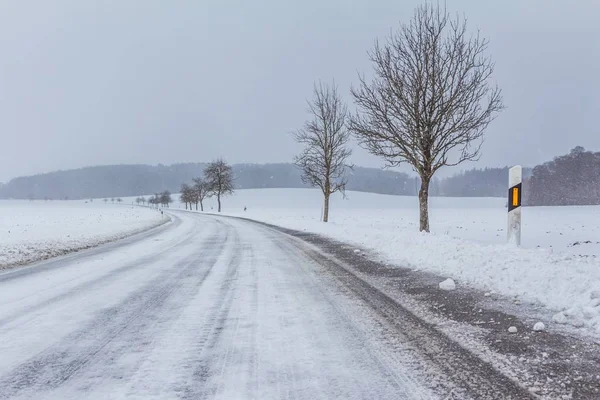 Beyaz karlı parça ile boş karlı buzlu kış yolu — Stok fotoğraf