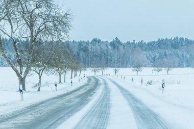 Yalnız, kaygan, buzlu kış yolu trafiği beyaz karlı yolda