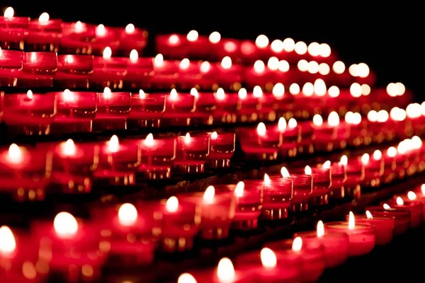 Kilisede bir grup kırmızı mum inanç dirilişi duası için — Stok fotoğraf