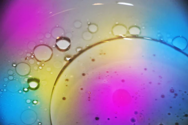 Oil drops on a water surface in neon light — Stock Photo, Image