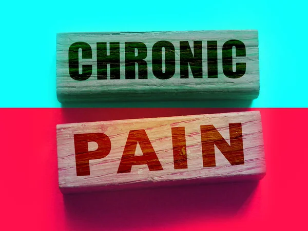 在蓝色和红色背景的对比中 木制块上的慢性疼痛词 医疗保健概念 — 图库照片
