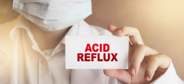 Doctor holding a card with Acid Reflux diagnosis. Healthcare medical concept.