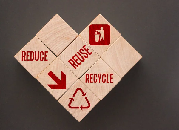 Reduce Reuse Recycle Words and icons on Wooden Cubes put in form of heart. Ecological concept.