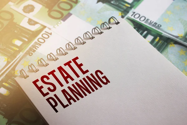 Estate Planning written on page of copybook put on 100 Euro banknotes. Real estate bent and buy business concept.