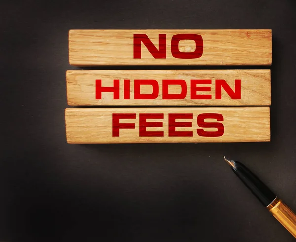 No hidden fees word written on wood block and luxury pen. Taxes and fees Financial business concept.
