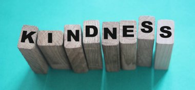 KINDNESS kelime ahşap yapı taşları ile yapılmış neon aquamarine arkaplan.