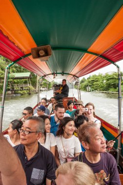Bangkok, Tayland, 27 Ocak 2018: Bangkok 'un banliyösündeki yüzen markette bir teknede turistler. Turistler için kanalda uzun bir kuyruk teknesi.