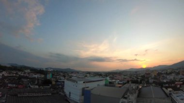 Tayland 'ın Phuket Adası' nın doğu kıyısından gün batımında Phuket Town ve deniz manzarası. Gündüzden akşama 4K zaman atlaması. Phuket eski şehir ve Büyük Budha heykeli gün batımında.