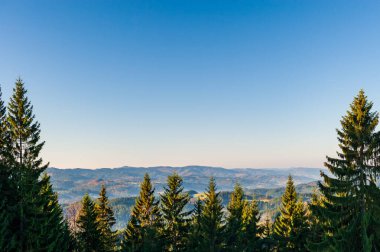 Sıcak gün batımı manzaralı vadide sisli Beskydy dağları ve mavi bulutsuz gökyüzü Çek dağlarında güneşli bir öğleden sonra, Beskid Slaski Lysa Hora Dağı yakınlarında..