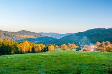 Sıcak gün batımı manzaralı vadide sisli Beskydy dağları ve mavi bulutsuz gökyüzü Çek dağlarında güneşli bir öğleden sonra, Beskid Slaski Lysa Hora Dağı yakınlarında..
