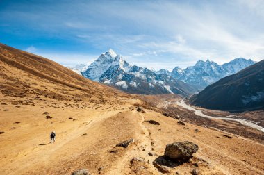 Dukh Koshi Vadisi 'nde yürüyüş yapan genç bir kadın ama Dablam tepesi olan Everest ana kampına gidiyor. Nepal Himalayaları 'nda gezinti. EBC (Everest ana kamp yürüyüşü), Lukla 'dan Everest yürüyüşünün EBC' sine kadar uzanır. Nepal.
