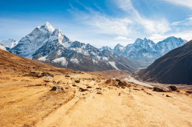 Dukh Koshi nehrinin, Ama Dablam zirvesi olan Everest ana kampına gitmesiyle çarpıcı bir vadi. Nepal Himalayaları 'nda gezinti. EBC (Everest ana kamp yürüyüşü), Lukla 'dan Everest yürüyüşünün EBC' sine kadar uzanır. Nepal.