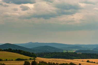 Tarlalarda ve ormanlarda gün batımı. Çayır üzerinde akşam güneşleri. Sumava, Bohem Ormanı, Bohmerwald, Çek Cumhuriyeti köylerinde sıcak güneş ışığı.