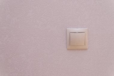 Duvardaki ışık düğmesi. Odadaki ışık duvarı. Elektrik var. Düğmenin kare şekli.