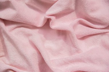 Pembe tüylü kumaş dokusu. Bebek battaniyesi arkaplanı. Güzel dalgalar ve kıvrımlar.