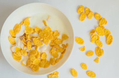 Koyu beyaz bir kasede sütlü mısır gevreği. Beyaz arka plan. Lezzetli ve sağlıklı Kahvaltı.