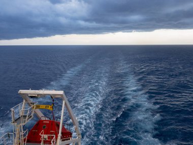 Bulutlu havada tekneye bakan kıç teknesi.